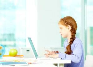 Child sitting up straight and typing (proper technique).