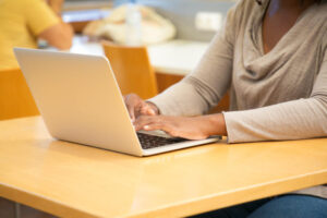 A lady sitting at a desk and typing, presumably taking her online lesson with Mary Lou.