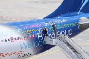 An airplane with the word "welcome" in many different languages written on the body.